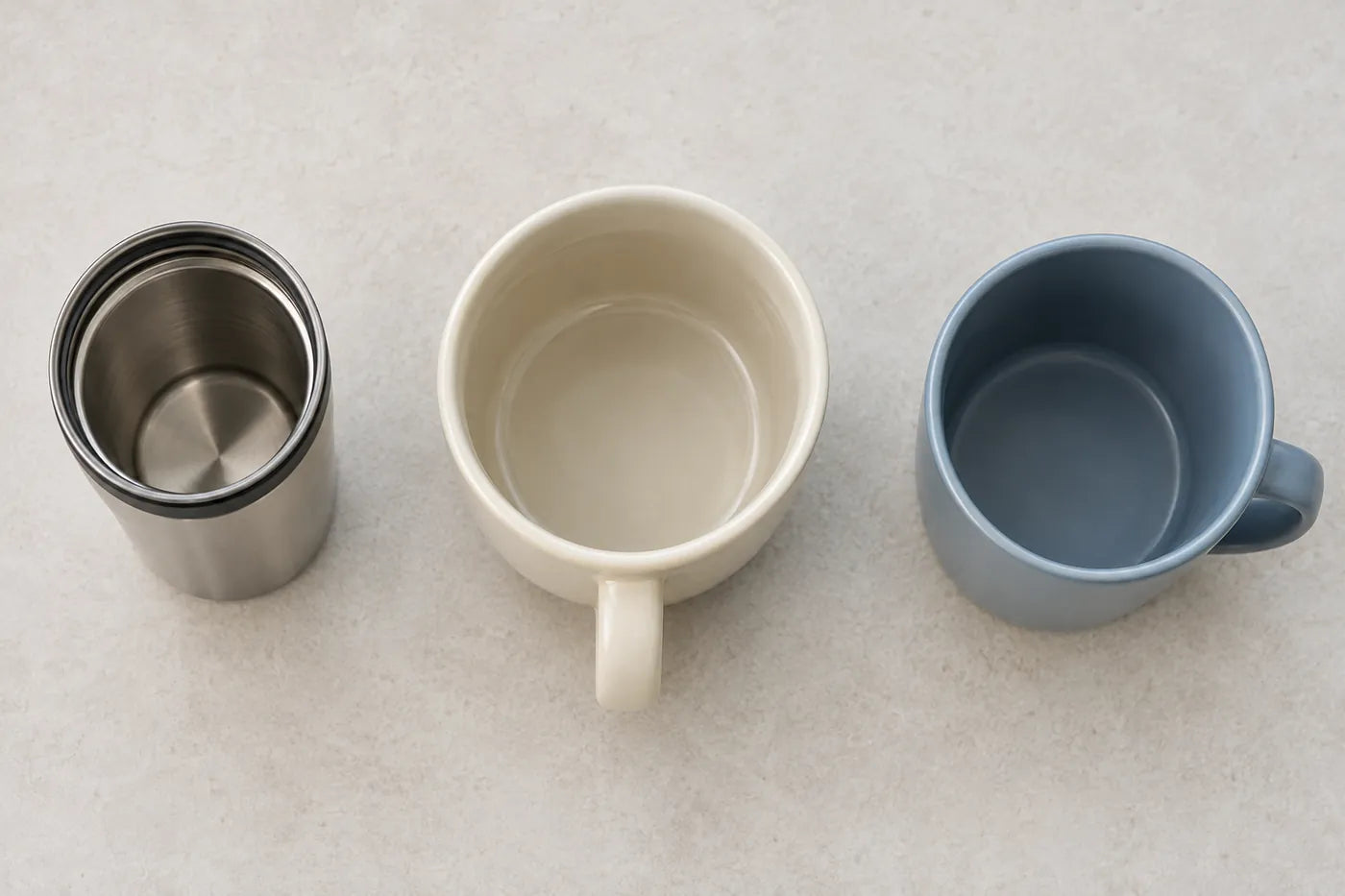 Top view of three empty mugs with a narrow opening, a broad ceramic rim and an oval opening